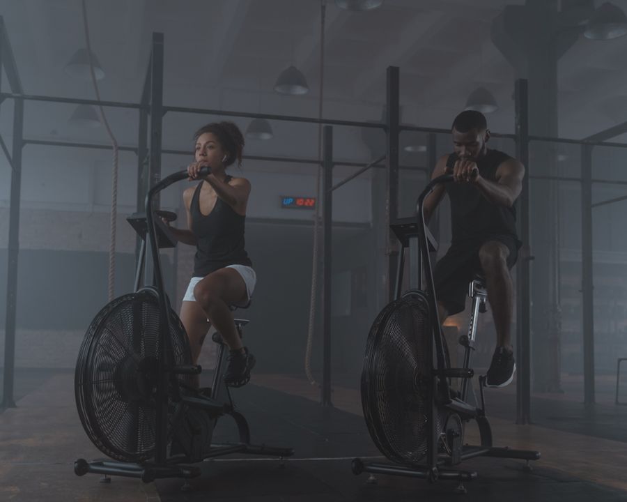 Dupla treinando em bicicletas de academia
